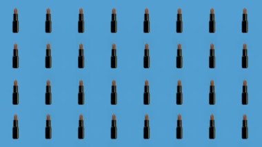 Mavi arka planda renkli ruj deseni. Rujla kusursuz desen. Üst Manzara. Gerçekçi animasyon. 4K video hareketi