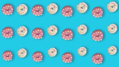 Mavi arka planda gölgeli izole edilmiş renkli çörek deseni. Donutla kusursuz desen. Çörekler. Üst Manzara. Gerçekçi animasyon. 4K video hareketi