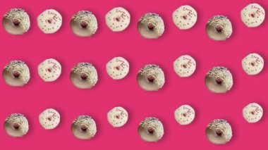 Pembe arka planda gölgeli izole edilmiş renkli çörek deseni. Donutla kusursuz desen. Çörekler. Üst Manzara. Gerçekçi animasyon. 4K video hareketi