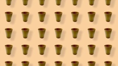 Turuncu arka planda gölgeli renkli kağıt bardaklar. Kağıt bardakla kusursuz desen. Üst Manzara. Gerçekçi animasyon. 4K video hareketi