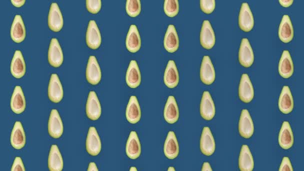 Kleurrijk fruitpatroon van verse avocado 's op blauwe achtergrond. Naadloos patroon met avocado. Realistische animatie. 4K video beweging — Stockvideo