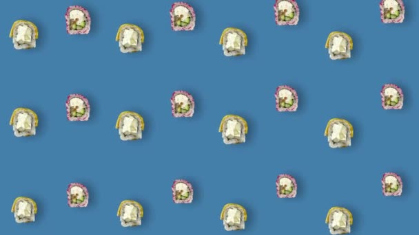 Patrón colorido de rollos de sushi japonés sobre fondo azul con sombras. Patrón sin costuras con sushi. Vista superior. Animación realista. Movimiento de vídeo 4K — Vídeos de Stock