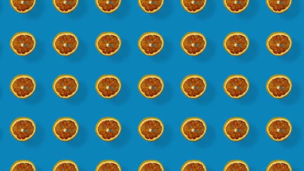 乾燥グレープフルーツスライスのカラフルなパターン影と青の背景に。ドライグレープフルーツチップとシームレスなパターン。現実的なアニメーション。4Kビデオモーション — ストック動画
