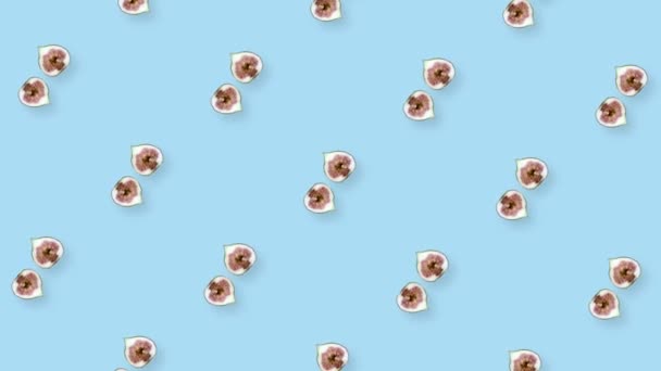 Bunte Fruchtmuster frischer rotierender Feigen auf blauem Hintergrund. Nahtloses Muster mit Feigenscheiben. Realistische Animation. 4K-Videobewegung — Stockvideo