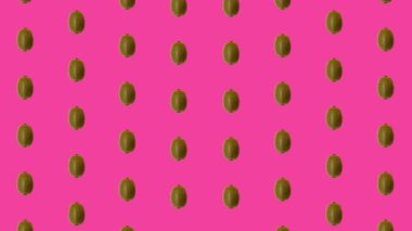 Pembe arka planda taze kivinin renkli meyve deseni. Kiviyle kusursuz desen. Gerçekçi animasyon. 4K video hareketi