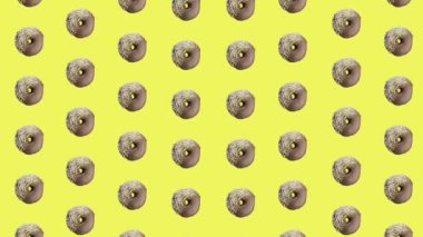 Sarı arka planda izole edilmiş renkli çikolatalı çörek deseni. Donutla kusursuz desen. Çörekler. Üst Manzara. Gerçekçi animasyon. 4K video hareketi