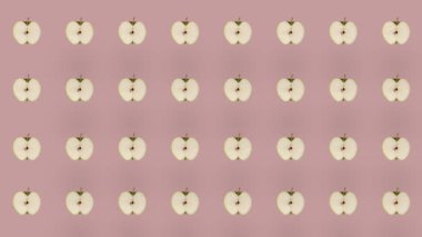 Pembe arka planda taze elmaların renkli meyve deseni. Elma dilimli kusursuz desen. Gerçekçi animasyon. 4K video hareketi