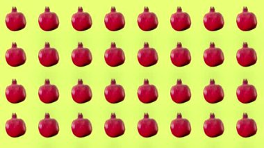 Sarı arka planda taze kırmızı nar renginde meyveler. Nar ile kusursuz desen. Gerçekçi animasyon. 4K video hareketi