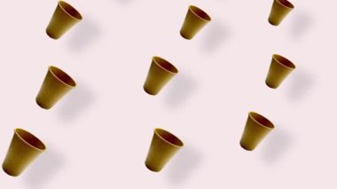 Pembe arka planda gölgeli renkli kağıt bardaklar. Kağıt bardakla kusursuz desen. Üst Manzara. Gerçekçi animasyon. 4K video hareketi