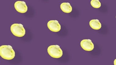 Menekşe arka planda gölgeli renkli prezervatif deseni. Prezervatifli kusursuz desen. Üst Manzara. Gerçekçi animasyon. 4K video hareketi