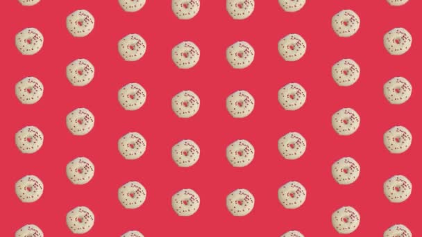 Красочный рисунок пончиков выделен на красном фоне. Бесшовный рисунок с пончиком. Пончики. Вид сверху. Реалистичная анимация. 4K видео движение — стоковое видео