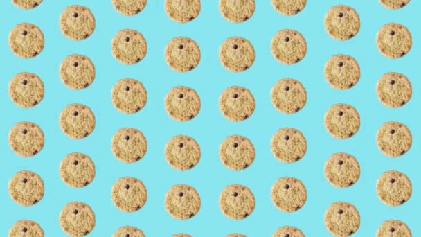 파란색 배경에 화려 한 초콜릿 칩 쿠키 패턴 이 있습니다. 쿠키를 곁들인 무뚝뚝 한 패턴. 위에서 본 모습. 리얼리티 애니메이션. 4K 비디오 모션 — 비디오