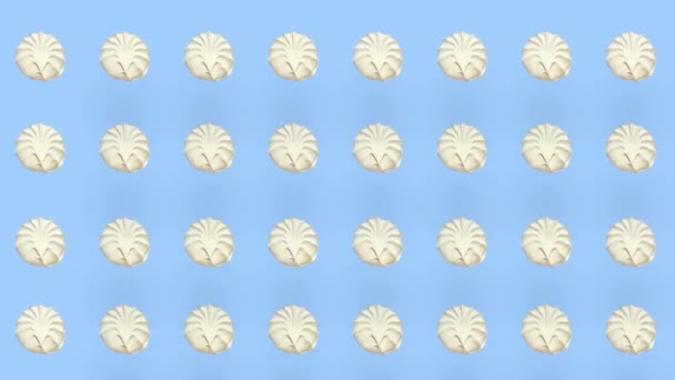 Kleurrijk patroon van witte zephyr op blauwe achtergrond met schaduwen. Naadloos patroon met zephyr. Marshmallow. Bovenaanzicht. Realistische animatie. 4K video beweging — Stockvideo