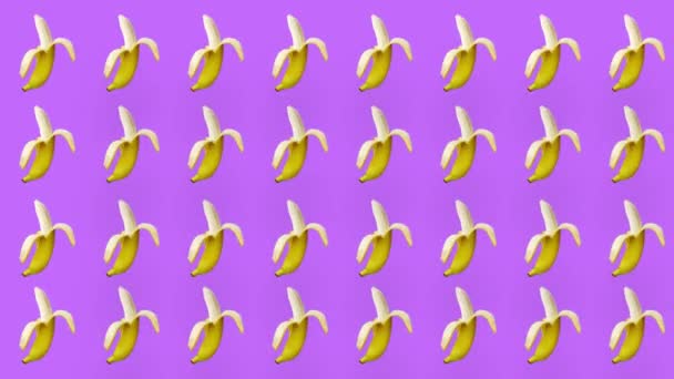 Colorful fruit pattern of fresh yellow bananas on purple background. Seamless pattern with banana. Realistic animation. 4K video motion — 图库视频影像