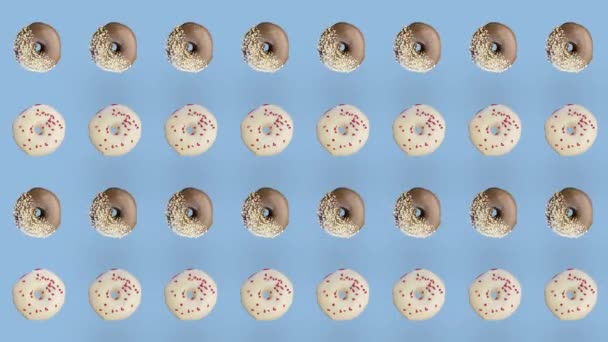 Kleurrijk patroon van donuts geïsoleerd op blauwe achtergrond. Naadloos patroon met donut. Donuts. Bovenaanzicht. Realistische animatie. 4K video beweging — Stockvideo