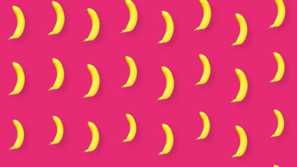 Padrão colorido de banana no fundo rosa. Vista superior. Conceito mínimo de verão de frutas tropicais. Padrão sem costura com banana. Movimento de vídeo 4K — Vídeo de Stock