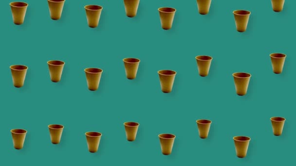 Colorful pattern of paper drinking cups on green background with shadows. Seamless pattern with paper cup. Top view. Realistic animation. 4K video motion — Stock Video