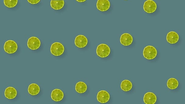 Pattern of limes repeated over colorful background. Top view. Minimal tropical fruit summer concept. Seamless pattern with lime slices. Realistic animation. 4K video motion — Stockvideo