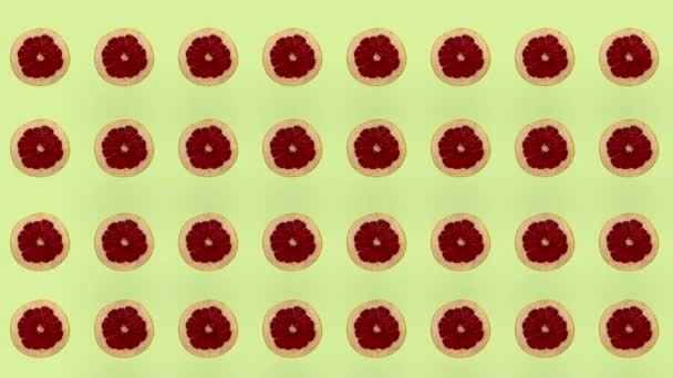 Barevný ovocný vzor čerstvých grapefruitů na žlutém pozadí. Bezešvé vzory s plátky grapefruitu. Realistická animace. Pohyb videa 4K — Stock video
