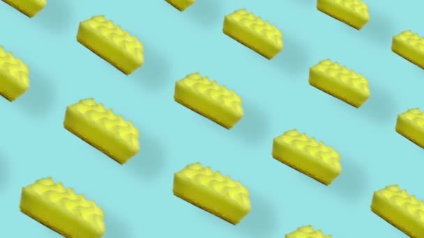 Patrón colorido de esponjas de cocina amarillas sobre fondo azul con sombras. Patrón sin costuras con esponja. Vista superior. Animación realista. Movimiento de vídeo 4K — Vídeos de Stock