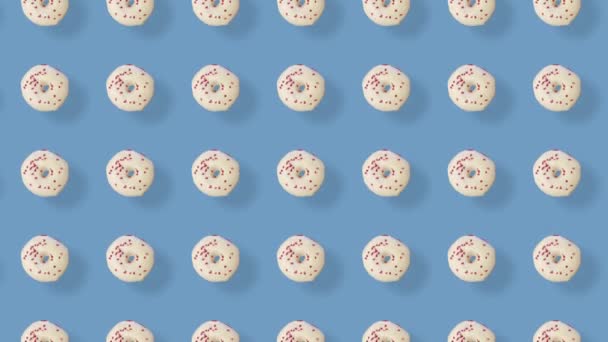 Colorful pattern of donuts isolated on blue background with shadows. Seamless pattern with donut. Doughnuts. Top view. Realistic animation. 4K video motion — Video Stock