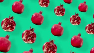 Yeşil arka planda gölgeli taze kırmızı nar renginde meyveler. Nar ile kusursuz desen. Gerçekçi animasyon. 4K video hareketi