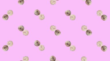 Pembe arka planda izole edilmiş renkli donut deseni. Donutla kusursuz desen. Çörekler. Üst Manzara. Gerçekçi animasyon. 4K video hareketi