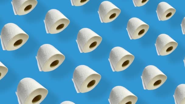 Colorful pattern of rolls of a white toilet paper isolated on blue background with shadows. Seamless pattern with toilet paper. Top view. Realistic animation. 4K video motion — Stockvideo