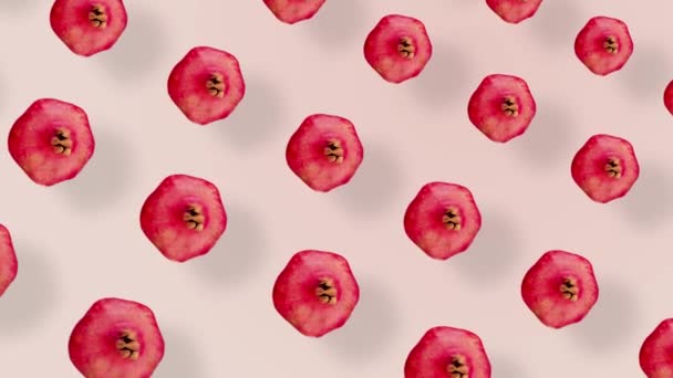 Kleurrijk fruitpatroon van verse rode granaatappels op roze achtergrond met schaduwen. Naadloos patroon met granaatappel. Realistische animatie. 4K video beweging — Stockvideo