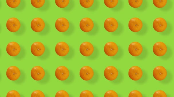 Bunte Fruchtmuster von frischem Orange auf grünem Hintergrund mit Schatten. Nahtloses Muster mit Orange. Realistische Animation. 4K-Videobewegung — Stockvideo