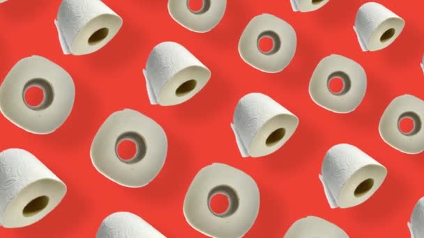 Colorful pattern of rolls of a white toilet paper isolated on orange background with shadows. Seamless pattern with toilet paper. Top view. Realistic animation. 4K video motion — Stockvideo
