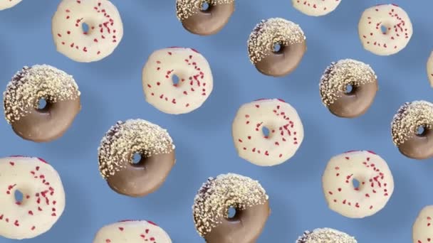 Πολύχρωμο μοτίβο ντόνατς που απομονώνονται σε μπλε φόντο με σκιές. Απρόσκοπτο μοτίβο με ντόνατ. Ντόνατς. Στο πάνω μέρος. Ρεαλιστική κίνηση. 4K κίνηση βίντεο — Αρχείο Βίντεο