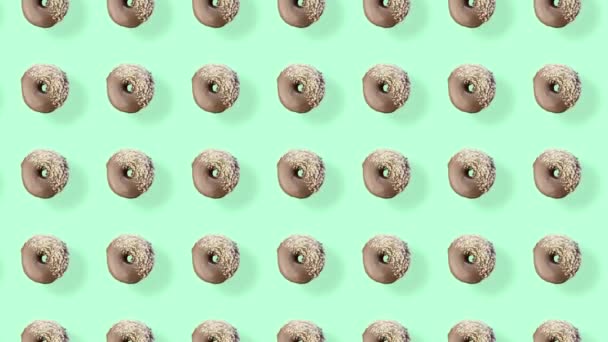 Colorful pattern of chocolate donuts isolated on green background with shadows. Seamless pattern with donut. Doughnuts. Top view. Realistic animation. 4K video motion — Stock Video