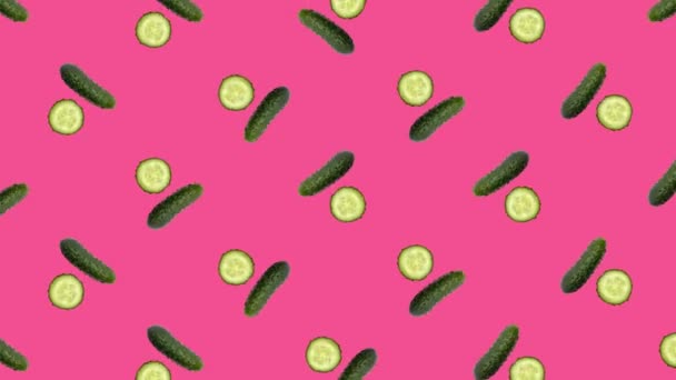 Colorful pattern of fresh rotating cucumbers on pink background. Top view. Seamless pattern with cucumber. Pop art design. Realistic animation. 4K video motion — Vídeo de Stock