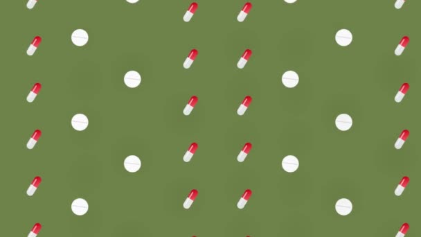 Patrón colorido de píldoras y cápsulas sobre fondo verde. Patrón sin costuras con tabletas. Concepto médico, farmacéutico y sanitario. Primer plano. Movimiento de vídeo 4K — Vídeo de stock