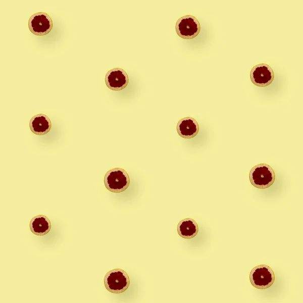 Πολύχρωμο μοτίβο φρούτων από φρέσκες φέτες γκρέιπφρουτ σε κίτρινο φόντο. Στο πάνω μέρος. Επίπεδη. Σχεδιασμός ποπ τέχνης — Φωτογραφία Αρχείου