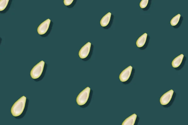 Buntes Muster frischer Avocados auf grünem Hintergrund mit Schatten. Ansicht von oben. Flach lag er. Pop-Art-Design — Stockfoto
