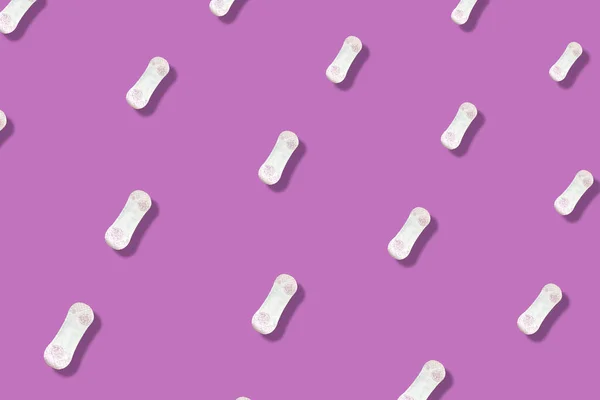 Kleurrijk patroon van dagelijkse damesmaandverband op roze achtergrond met schaduwen. Menstruatiepad. Bovenaanzicht. Vlakke plaat — Stockfoto