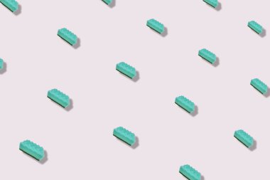 Gri arka planda turkuaz mutfak süngerlerinin renkli deseni. Üst Manzara. Düz yatıyordu. Pop sanat tasarımı