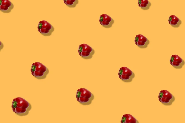 Buntes Muster von frischem Paprika auf orangefarbenem Hintergrund mit Schatten. Bulgarischer roter Pfeffer. Ansicht von oben. Flach lag er. Pop-Art-Design — Stockfoto