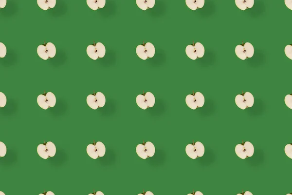 Yeşil arka planda gölgeli kesilmiş taze yeşil elmaların renkli meyve deseni. Üst Manzara. Düz yatıyordu. Pop sanat tasarımı, yaratıcı yaz konsepti — Stok fotoğraf
