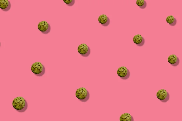 Bunte Fruchtmuster von frischem Cherimoya auf rosa Hintergrund mit Schatten. Puddingapfel vorhanden. Ansicht von oben. Flach lag er. Pop-Art-Design — Stockfoto