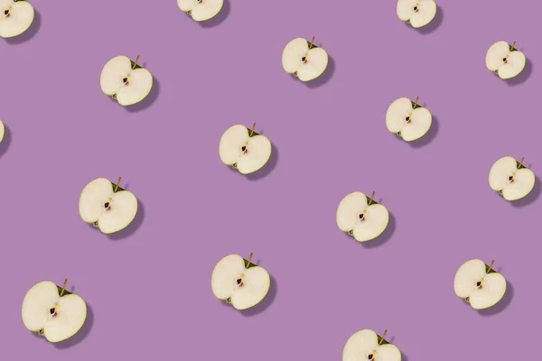 Barevný ovocný vzor čerstvě zelených jablek krájených na růžovém pozadí se stíny. Horní pohled. Ležel. Pop art design, kreativní letní koncept — Stock fotografie