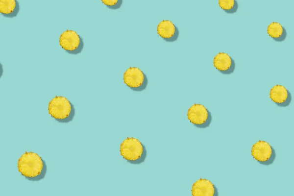 Kleurrijk fruitpatroon van ananas gesneden op groene achtergrond met schaduw. Bovenaanzicht. Plat gelegd. Pop art ontwerp — Stockfoto