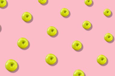 Pembe arka planda taze yeşil elmaların gölgeli renkli meyve deseni. Üst Manzara. Düz yatıyordu. Pop sanat tasarımı, yaratıcı yaz konsepti