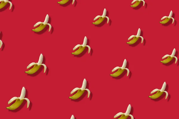Kleurrijk fruitpatroon van gele bananen op rode achtergrond. Bovenaanzicht. Plat gelegd. Pop art ontwerp — Stockfoto