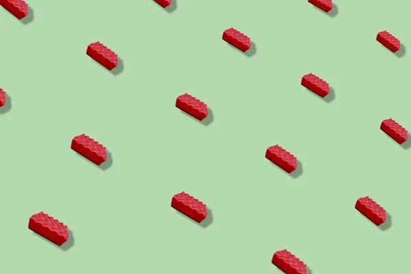 Patrón colorido de esponjas de cocina rosadas sobre fondo verde con sombras. Vista superior. Acostado. Diseño de arte pop — Foto de Stock