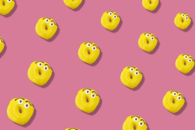 Pembe arka planda gölgeli sarı renkli donutlar. Çörekler. Üst Manzara. Düz yatıyordu
