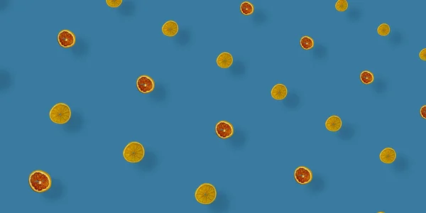 Барвистий візерунок із сушених грейпфрутів та апельсинів на синьому фоні. Сушені грейпфрутові та апельсинові чіпси. Вид зверху. Пласка лежала. Поп-арт — стокове фото
