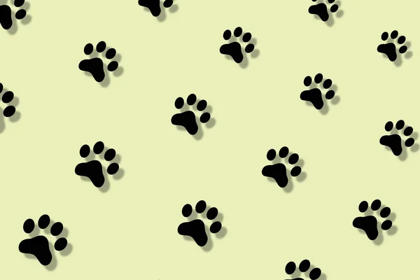 影のある黄色の背景に猫の爪のカラフルなパターン。猫の足でシームレスなパターン。犬、猫の足跡の背景 — ストック写真